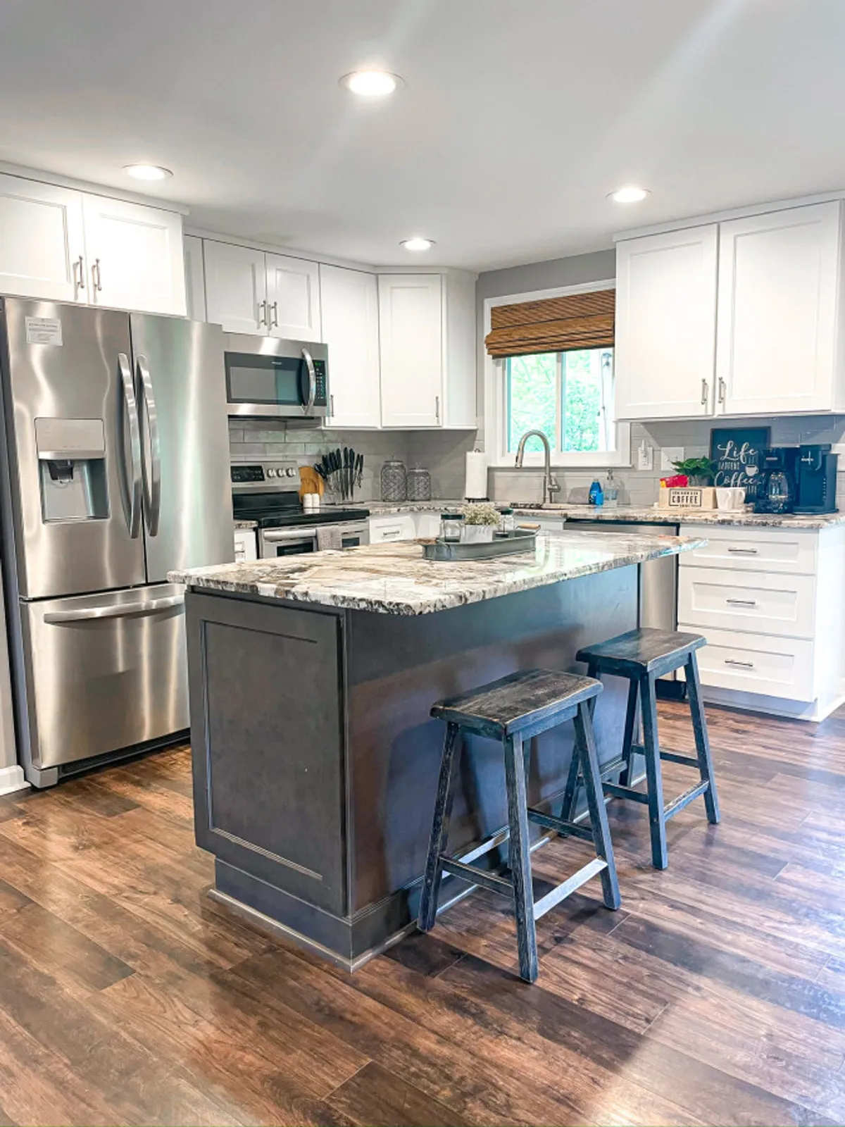 A granite countertop with wooden bar stools, modern stainless steel appliances, and a welcoming kitchen island, suggesting a space ideal for both meal prep and casual conversation. The scene feels ready for cooking and entertaining alike.
